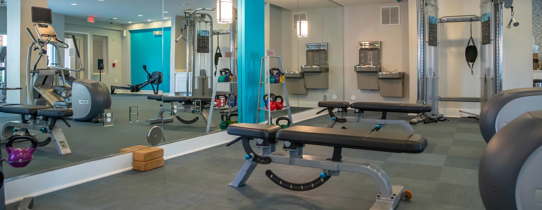 large fitness center with wall of mirrors